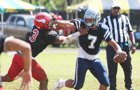 Samoana Sharks quarterback Viliamu Tanielu trying to hold off a vicious blitz by Ronnie Oa of