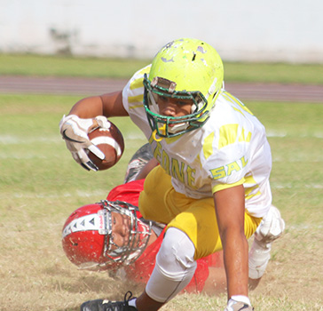 A Leone Lions running back is dragged down in the backfield by a Viking defender