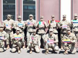 Diverse members of 773rd Civil Support Team, wih flags of their countries of origin.