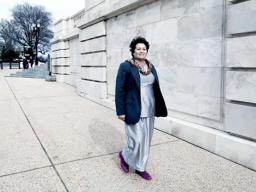 Amata outside in Washington D.C. walking toward her office building.