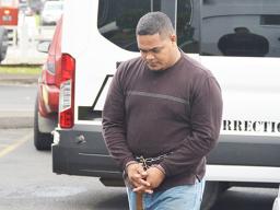 Amosa Lautaimi, handcuffed and making his way to the District Court yesterday morning for his initial appearance