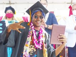 ASCC grad with his diploma, Lt. Gov in the background