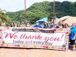 DOE admin holding up Teacher Appreciation Week banner