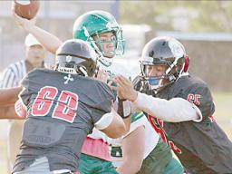 Leone Lions quarterback, Elisara focused and locked-in to make a pass just before getting tackled by two Marist Crusader defenders 