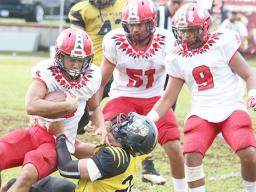 Faga’itua Vikings O’Neil Ah-Chee struggling to break a tackle against a Nu’uuli Wildcats defender 