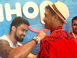 Samoan NFL player Shalom Luani autographing a shirt for one of the players from the U18 Amerika Samoa National Baseball Team