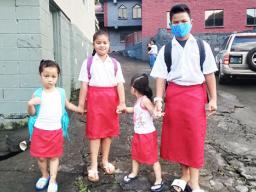 Matafao Elementary School students holding hands on their way to school