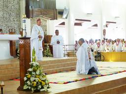 Bishop-elect Reverend Father Etuale kneels