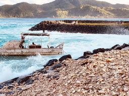 A boat in rough surf at Aunuu
