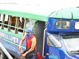 Man with scarf face covering exits a bus
