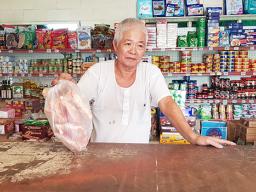 Mr Lin of Peta Lin Store holds bag of chicken