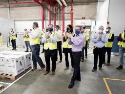 Pfizer employees clap after line workers finished packing boxes of vaccine