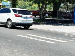 Car passes crosswalk with faded paint