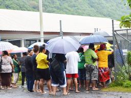 Crowd with umbrellas waiting at DMWR gate