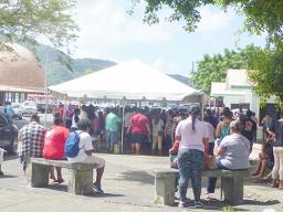 A crowd gathered at Social Service office under the tents with no social distancing