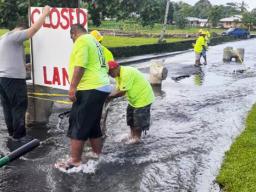 DPW crew installing lane closed sign where Fagaima road is flooded