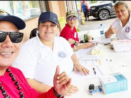 Three HR staffers manning a Tonga relief donation booth