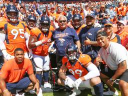 The defensive line group — Derek Wolfe (95), Shelby Harris (96), Zach Kerr (92), Domata Peko Sr. (94), Kyle Peko (90), DeMarcus Walker (57) and Adam Gotsis (99) — take a group photo with Peko Sr.'s father