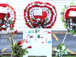 Flowers with photographs in place at the site where three Manu'a Store employees died