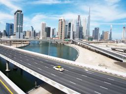 A lone taxi cab drives over a typically gridlocked highway with
