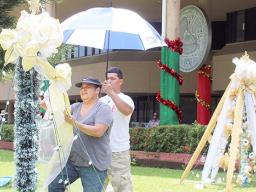 Two ASG employees hang Christmas lights at the EOB