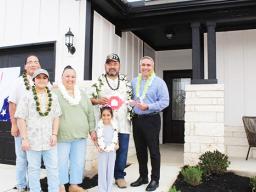 Taetuli and family in front of their new home.