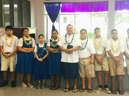 Rev. Father Kolio Etuale (middle) surrounded by students of St. Theresa Elementary School