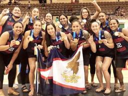 The American Samoa women’s basketball team celebrate atop the podium with their gold medals.