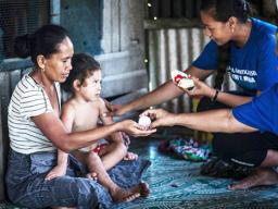 Lead coordinator Susitina Lene helps to administer treatment to a family in Leauvaa