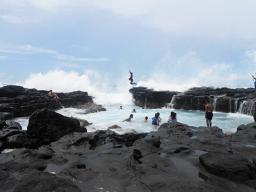 Kids jumping into an ocean tide pool
