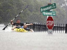 Flooding in Houston with two men paddling in the water