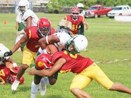 Joshua Taani of the Leone Lions is met by a Tafuna Warrior defender