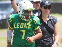 ASHSAA ATC Florence Wasko helping injured Leone Lions quarterback Isaiah Elisara off