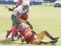 A Leone Lion defender tries to break away from two Tafuna Warriors