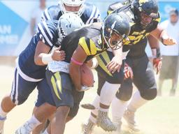 Joe Savaii trying to escape the grasp of a Samoana defender 