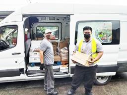 Two men and truck with food for delivery