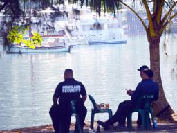 Homeland security personnel siting on shore in sight of yacht
