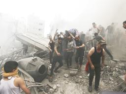 Palestinians remove a dead body from the rubble of a building after an Israeli airstrike