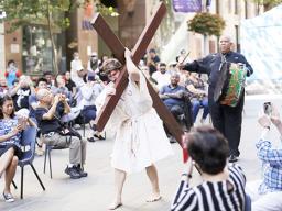 Actor Timothy Watkins carries a cross 