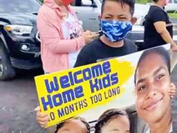 Young boy holding welcome banner