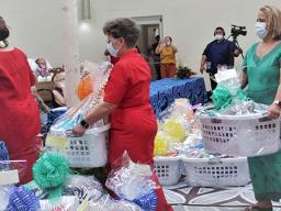 Three female staff members carrying gift baskets into Hope House