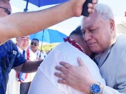 Tuila'epa Sa'ilele Malielegaoi in the arms of the Head of State
