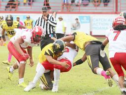 Faga'itua Vikings ball carrier Roy Ulugalu is tackled by two Nu’uuli Wildcat defenders 