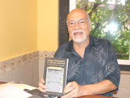Author Fuimaono Fini Aitaoto holds a copy of his new book