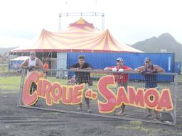 Employees of The Magic Circus of Samoa posing with their sign