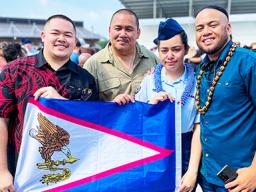 Kathlynn Faaita with family holding an American Samoa flag
