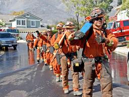 Firefighters march into an L.A. neighborhood threatened by wildfire.