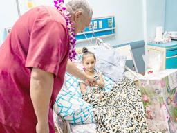 Gov. Lemanu P.S. Mauga delivering gift to a child patient at LBJ
