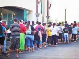 A crowd of people seen standing in line outside of the Territorial Bank of American Samoa (TBAS) waiting for the bank to open so they could cash their stimulus checks
