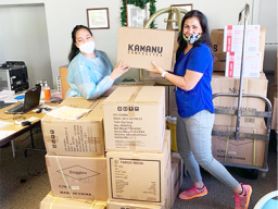 Two women receiving donated items in boxes